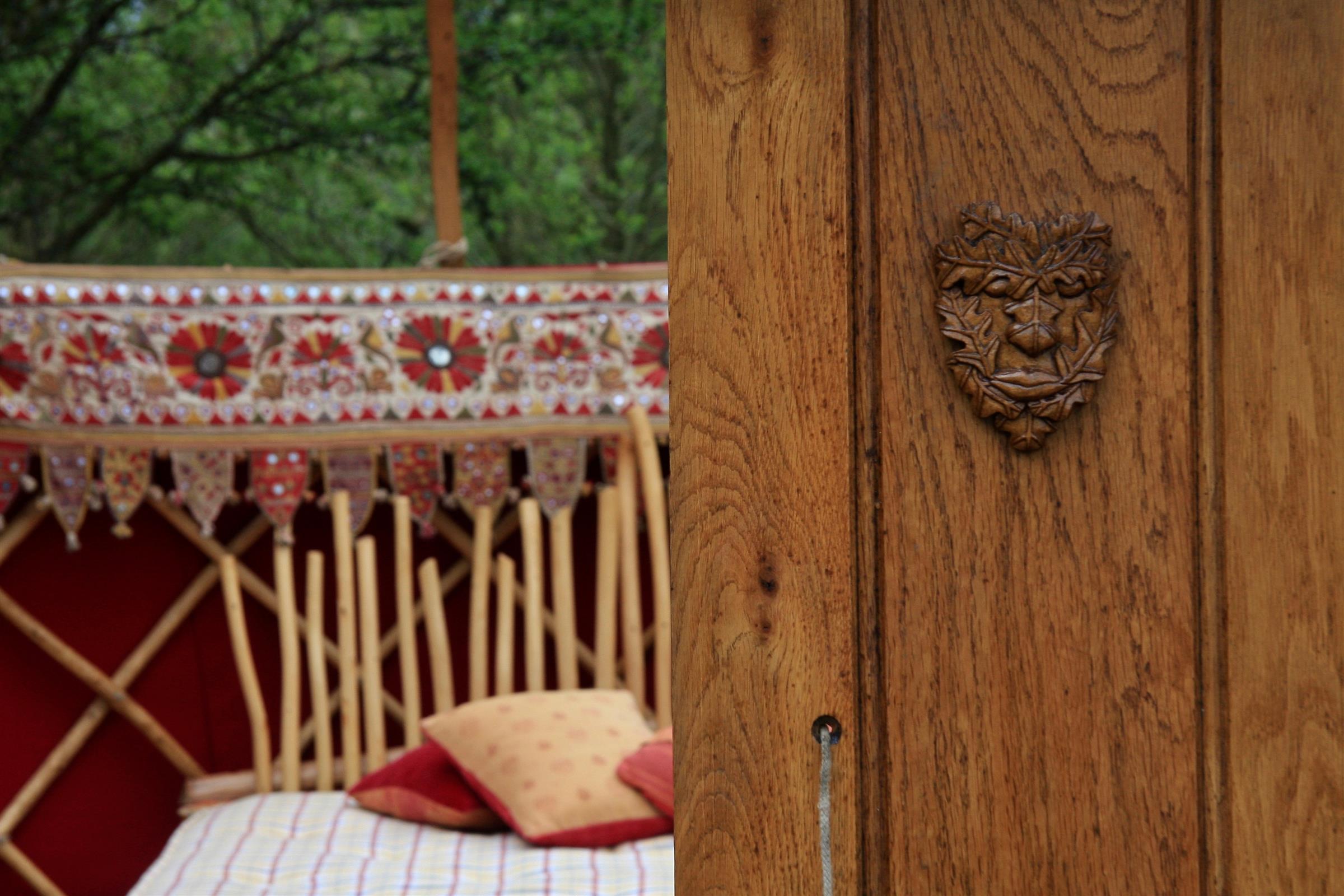 Green Man carving on the door of the yurt